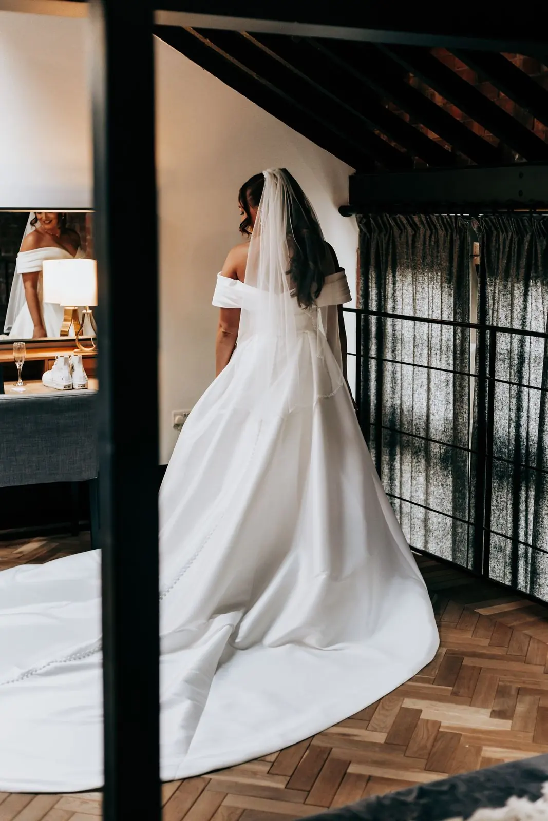 Bride in a satin gown with a long train from behind