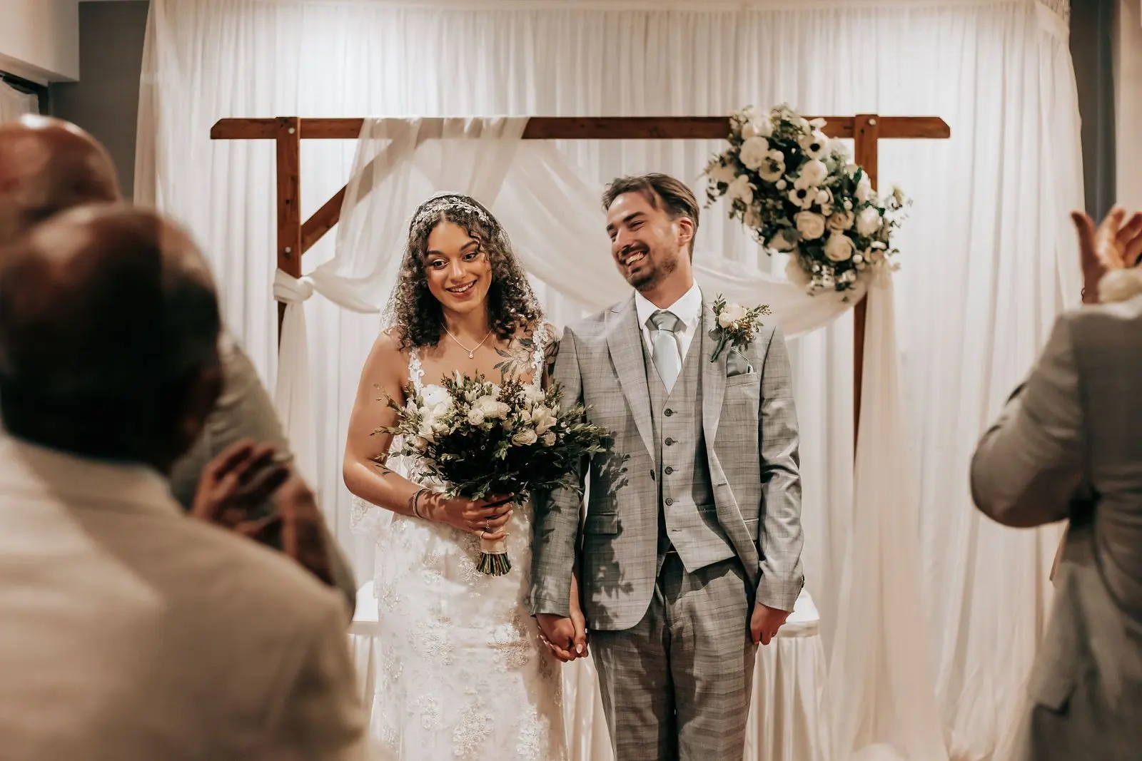 Couple laughing after the ceremony with guests around them